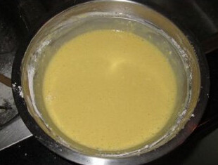 椰香轻乳酪蛋糕,分3次将蛋白加入到蛋黄液里，由上而小的搅匀，装入模具内