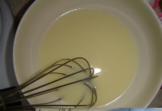 酒渍葡萄干戚风,将15g糖、油以及牛奶混合后，用打蛋器搅打混合，呈米汤状