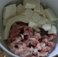 西葫芦肉盒子,将一些嫩豆腐与绞好的肉馅倒在碗里准备，将调味倒入拌均