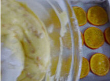 橙香蛋糕,将橙片部分从小锅中捞出，铺到烤盘上后倒入面糊
