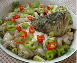 清蒸鱼,取出蒸好的鱼,再在鱼身上放些葱花, 青红辣椒。用勺子烧热花椒油淋在上面
