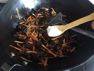 炒三丝,热锅倒油，下入黑木耳，胡萝卜丝翻炒，加入适量盐