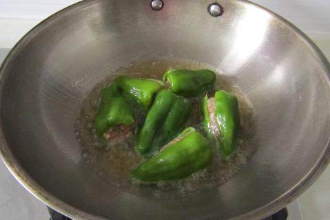 虎皮青椒酿肉,油锅，中火煎炸青椒，将青椒炸制起皱变色