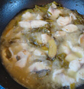 酸菜鱼,锅中倒入开水，加入少许的酸菜叶，煮五分钟后用漏勺捞出鱼骨头。