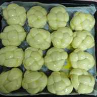 绣球面包,放入烤盘中，盖上保鲜膜入烤箱发酵40分钟后，拿出刷上蛋液