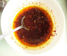 红油猪耳拌黄瓜,熬好的油，滤出花椒等，趁热浇到辣椒末上即可