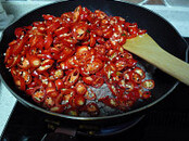 私房辣椒酱,油锅加入碎肉，翻炒变色后加蒜粒，翻炒出蒜粒香味后，加辣椒碎
