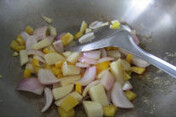香蕉咖喱鸡丁烩饭 ,油锅放入洋葱丁翻炒出香味后，放入土豆丁和彩椒丁继续翻炒片刻