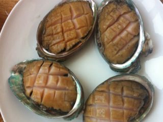 蒜香鲍鱼,如图，鲍鱼肉切十字花刀，放到鲍鱼壳里。