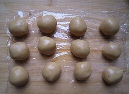 广式豆沙月饼,筛入低筋面粉，混合成面团，包上保鲜膜醒一小时后分成20g一个小球
