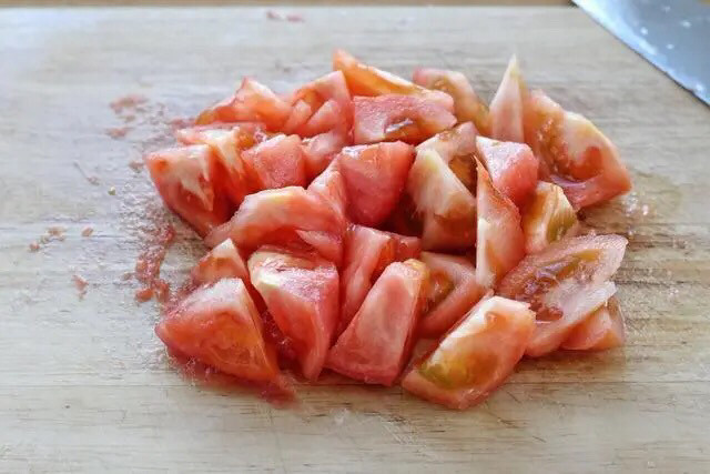 金针菇番茄汤,捞出番茄立刻冲凉水，将外皮撕掉切成滚刀块。