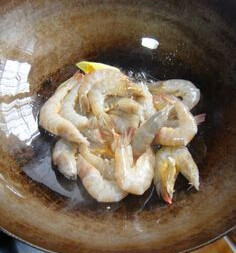 油焖青虾,油锅放入葱姜段炒香。放入虾，二面煎红