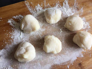 冰皮月饼,案板上撒些熟糯米粉防粘，将蒸熟的面团揉成长条，然后揪成剂子