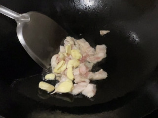土豆回锅肉,煸出油分后加入拍好的蒜头