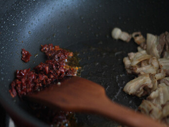 干锅茶树菇,油锅放入五花肉煸炒出油，把肉片拨到一边，倒入剁碎的郫县豆瓣炒出红油