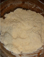 黑芝麻咸香饼干,低粉、泡打粉、盐混合过筛后，加入细砂糖和软化的黄油，用手搓匀，成为粗玉米粉的状态