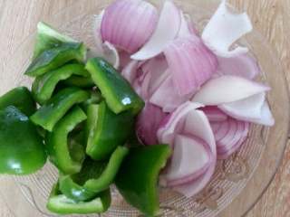 洋葱青椒炒鱿鱼,青椒、洋葱洗干净切片待用。如图。