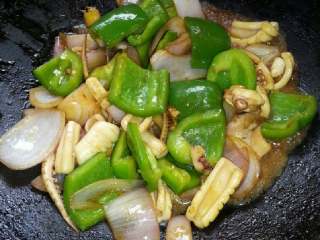 洋葱青椒炒鱿鱼,加上椒翻炒、加上酱油搅拌、盖上锅盖、煮1分钟后打开盖烧至收汁即可、再加上葱丝完成。