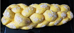南瓜豆沙辫子面包,表面刷蛋液，手指沾水后沾白芝麻，然后印在辫子凸起的地方