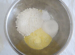 玉米蒸糕,把玉米面、普通面粉、泡打粉、糖先混合拌匀