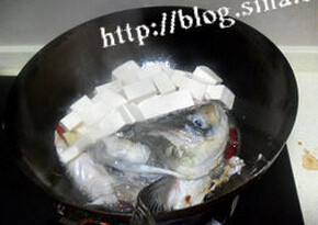 鱼头豆腐汤,鱼头翻身，加入咸肉片和豆腐再一起煎一分钟