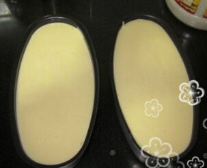 牛奶轻乳酪蛋糕,分3次将蛋白加入到蛋黄液里，由上而下的搅匀,装入模具内