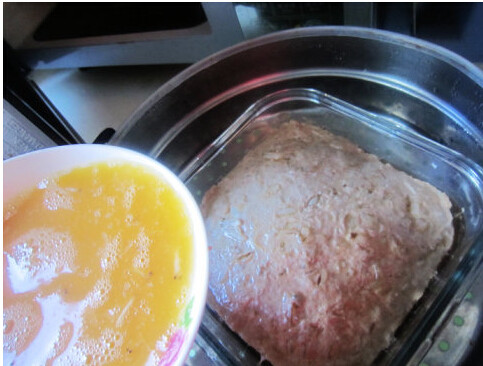 蛋蒸土豆丝肉饼,肉饼蒸20分钟后取出，倒入准备好的鸡蛋液。继续蒸10-15分钟