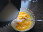 芒果奶冻,将牛奶液倒入芒果泥中，搅拌均匀