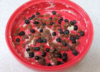 芙纽多,模具内部涂抹较大量的软化黄油，在模具中放入蓝莓干和葡萄干铺均匀