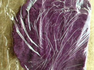 Q弹紫薯馅花朵面包,取70g紫薯肉，撕一大张保鲜膜对折包起来，用擀面杖压成泥。这方法太赞了，压得很细腻！