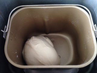 Q弹紫薯馅花朵面包,主面团材料除了黄油外，全部倒进面包机搅拌桶，开启15分钟揉面程序后，加入黄油（无需软化），再揉至可以拉出薄膜。静置在面包机里发酵至两倍大。