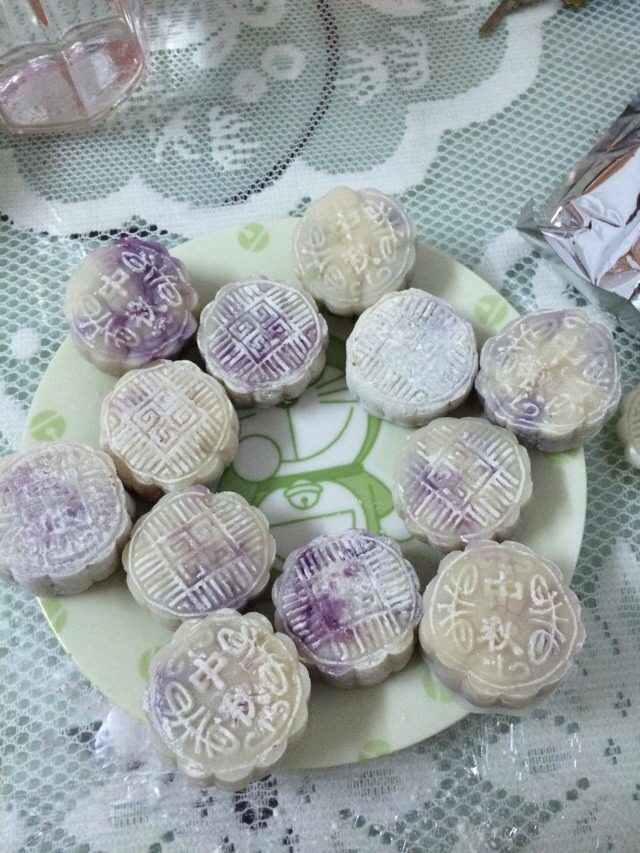 自制紫薯冰皮月饼,把粉团压扁，放入紫薯团，和汤圆一样包好，然后用月饼模定型就完成啦