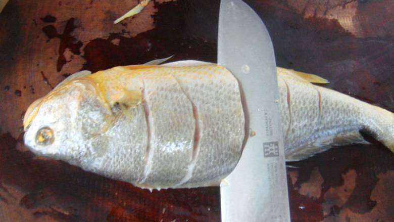 清蒸黄鱼,把鱼去内脏和腹部内的黑膜，去鳞去鱼鳃两面都切花刀