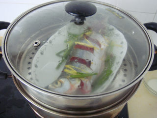 清蒸白水鱼,之后锅内烧水水烧开后放入鱼大火8分钟后熄火加盖焖2分钟端出，去掉鱼背上葱断，加入切成细丝的青椒和鲜酱油
