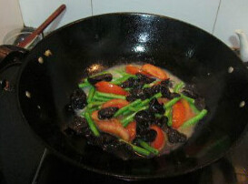 西红柿黑木耳炒豇豆,油锅，放入蒜头，爆至油7成热时，将西红柿炒1分钟，再放入豇豆和黑木耳倒入翻炒2分钟