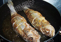 醋焖黄花鱼,在鱼身上拍上干粉,下油锅煎至两面金黄