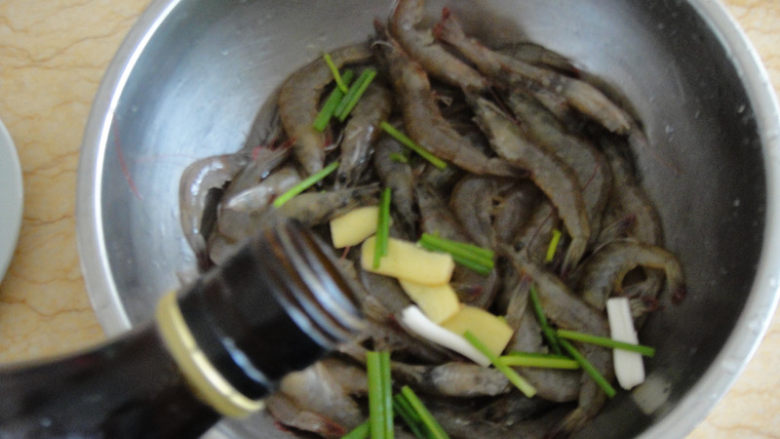 油爆虾,先用料酒，葱段和生姜片把虾腌制20分钟去腥