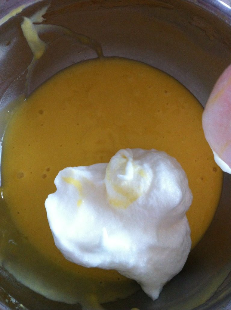 波点戚风蛋糕卷,如图，取三分之一蛋白到蛋黄里，翻拌均匀。