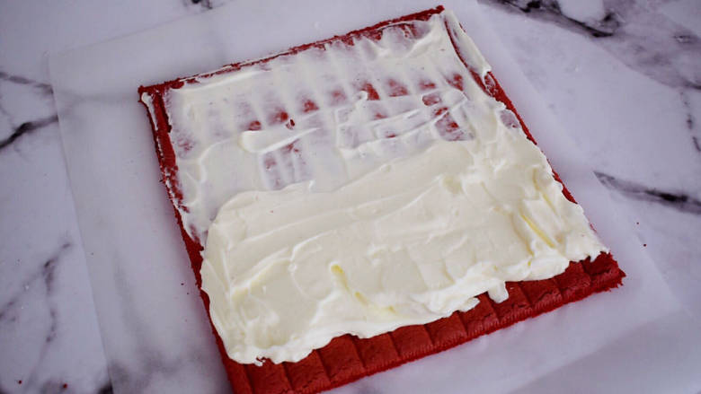 红曲蛋糕卷,表面抹上奶油

