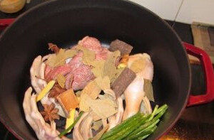 卤味,锅内放入牛肉、鸭掌，放上香葱、八角、香叶、桂皮、姜