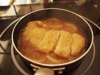 猪排丼,取一个小锅子（用小锅子刚好一人份，如果人多，可以用大的平底锅，一下子做多份），锅子里面放入柴鱼汤（昆布放水里浸一晚上最好，然后放入柴鱼一起煮开晾凉就可以了）、切条的<a style='color:red;display:inline-block;' href='/shicai/ 29'>洋葱</a>，一勺味啉，一勺砂糖，一勺生抽，开火煮，这个时间把炸好的猪排切块，等汤有点煮开的时候把猪排放进去煮一会儿让猪排吸饱汤汁。