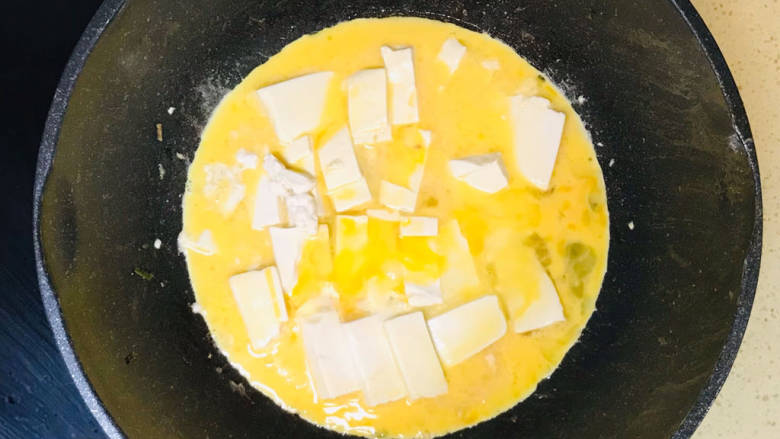 鸡蛋炖豆腐,倒入鸡蛋液，继续慢火煎至凝固