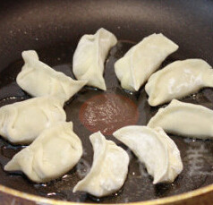冰花煎饺,让油在锅底均匀，开火，锅烧热后，放入饺子，煎1分钟左右定型