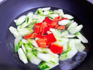 黄瓜炒鱿鱼,锅中烧开水，放入黄瓜和红椒