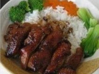 照烧鸡肉饭,米饭盛入碗内，将鸡腿肉和各种蔬菜摆在米饭上，淋上浓稠的照烧汤汁即可。