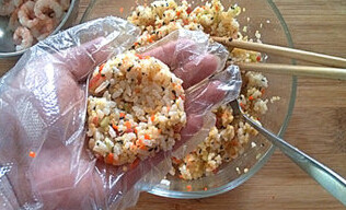 紫菜饭团子,取饭团放入手心中，借助小勺在米饭的中间压一个窝