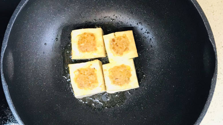 煎酿豆腐,锅里加油，烧热，加入豆腐块，慢火煎至四面金黄色