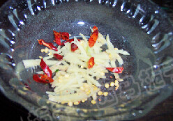 麻辣蓑衣黄瓜 ,把姜切成丝放到碗中，加入剪碎的干辣椒