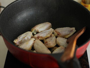 话梅鸡翅,油锅放入鸡翅煎至两面金黄