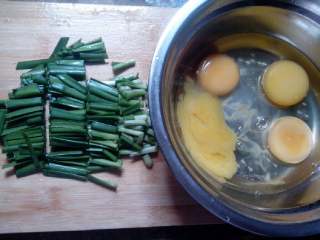 韭菜炒鸡蛋（家常菜）,把鸡蛋打入碗里，叫盐搅拌均匀，韭菜切小段。